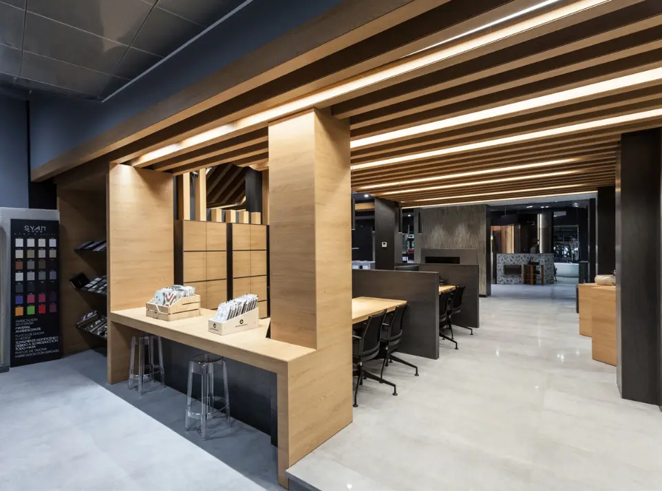 Oficinas modernas en Andorra con diseño interior en madera e iluminación lineal LED integrada.