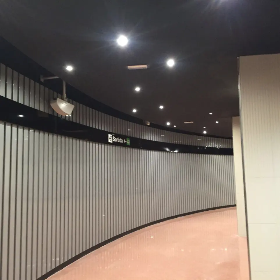 Iluminación direccional en pasillo curvo de la estación de metro Plaça Universitat, Barcelona.