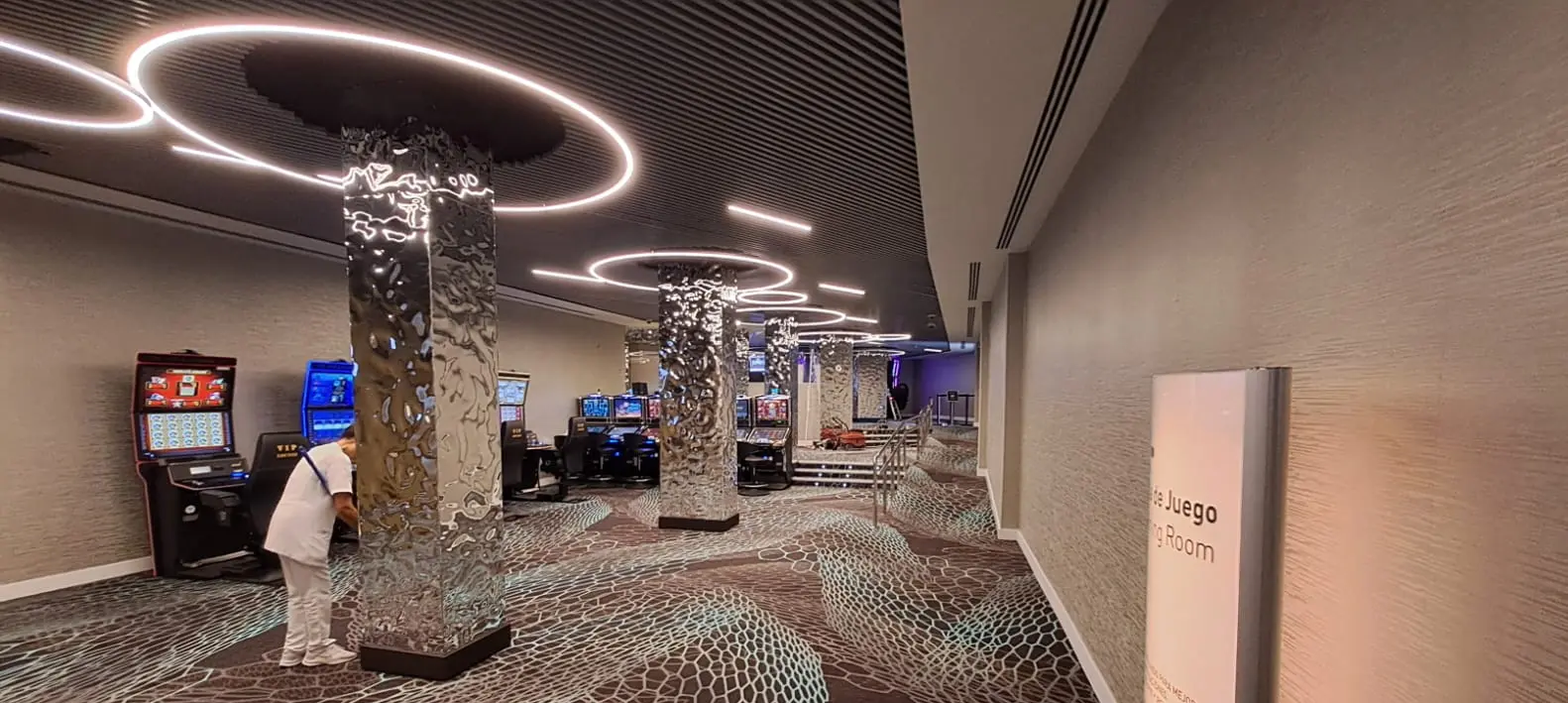 Diseño de iluminación LED con columnas reflectantes y anillos de luz en el acceso al Casino Marbella.