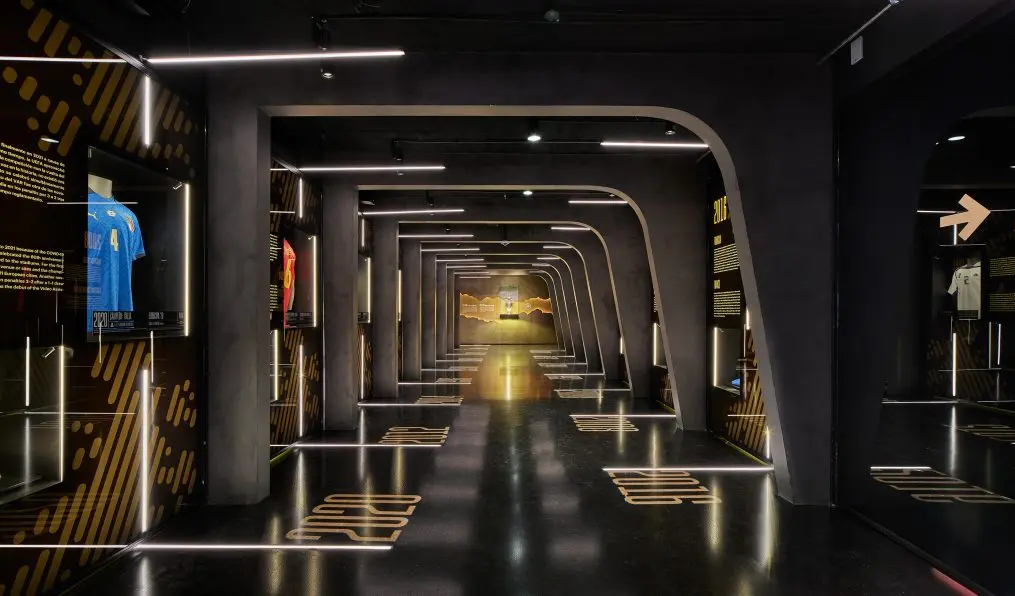 Corredor expositivo del Museo Legends con líneas de luz LED integradas en paredes y suelo.