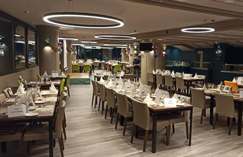 Iluminación LED decorativa con aros suspendidos en el restaurante del Hotel Panorama, diseño lumínico de Luxes.